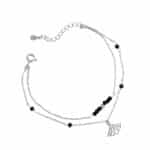 Podwójna srebrna bransoletka typu celebrytka z czarnymi koralikami.