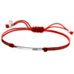 Srebrna bransoletka na czerwonym, podwójnym sznurku z blaszką ze znakiem nieskończoności.