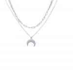 naszyjnik z zawieszką w kształcie księżyca zawieszoną na ankierku. Drugi łańcuszek osplocie spinacza biurowego. Łańcuszki wiszą kaskadowo jeden pod drugim.